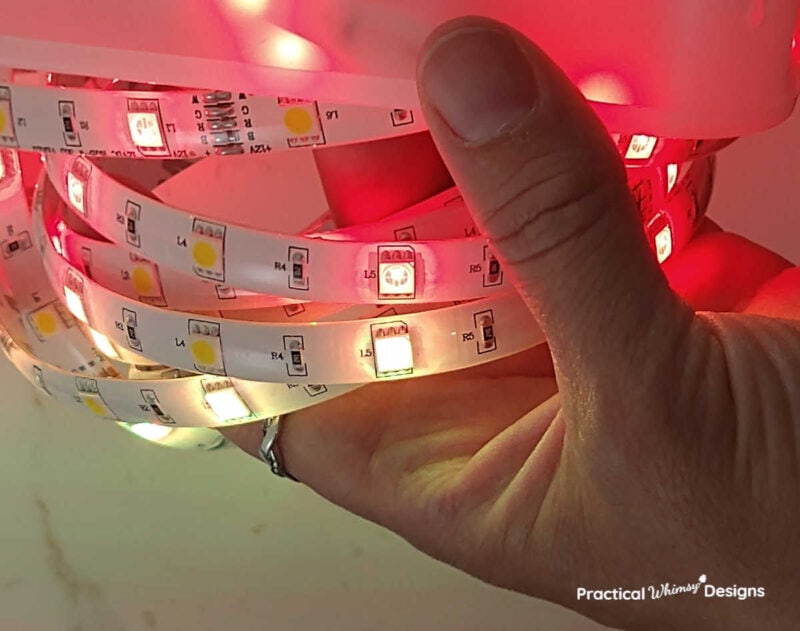 Hand holding red LED tape light.