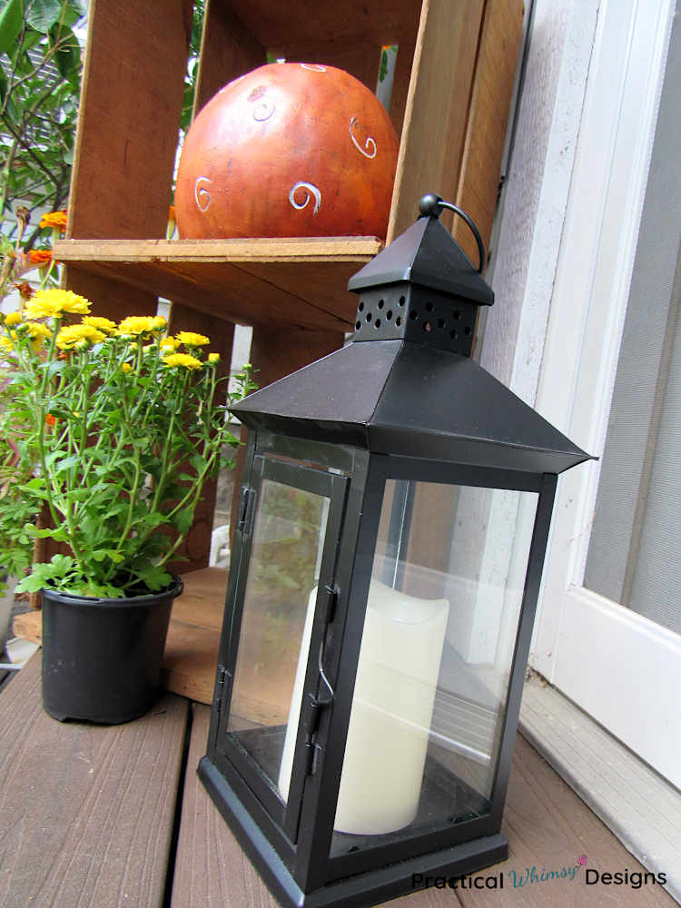 Lantern and pumpkin as small porch fall decor.