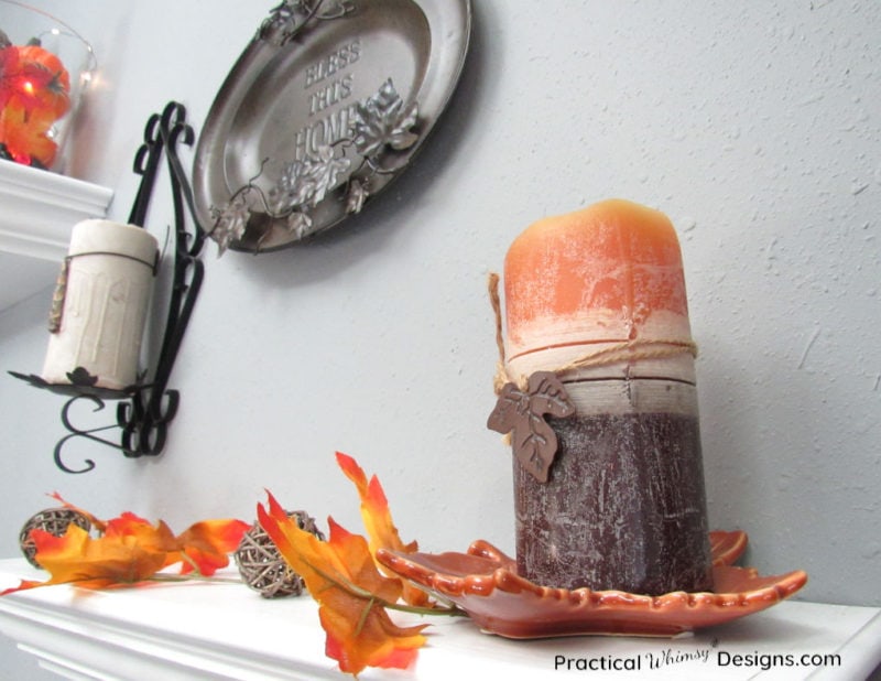 Candles on shelf with orange leaf vine