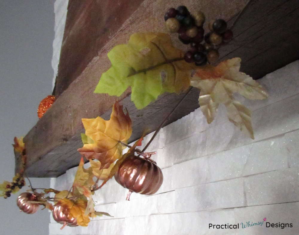 Fall pumpkin and leaf garland on mantel