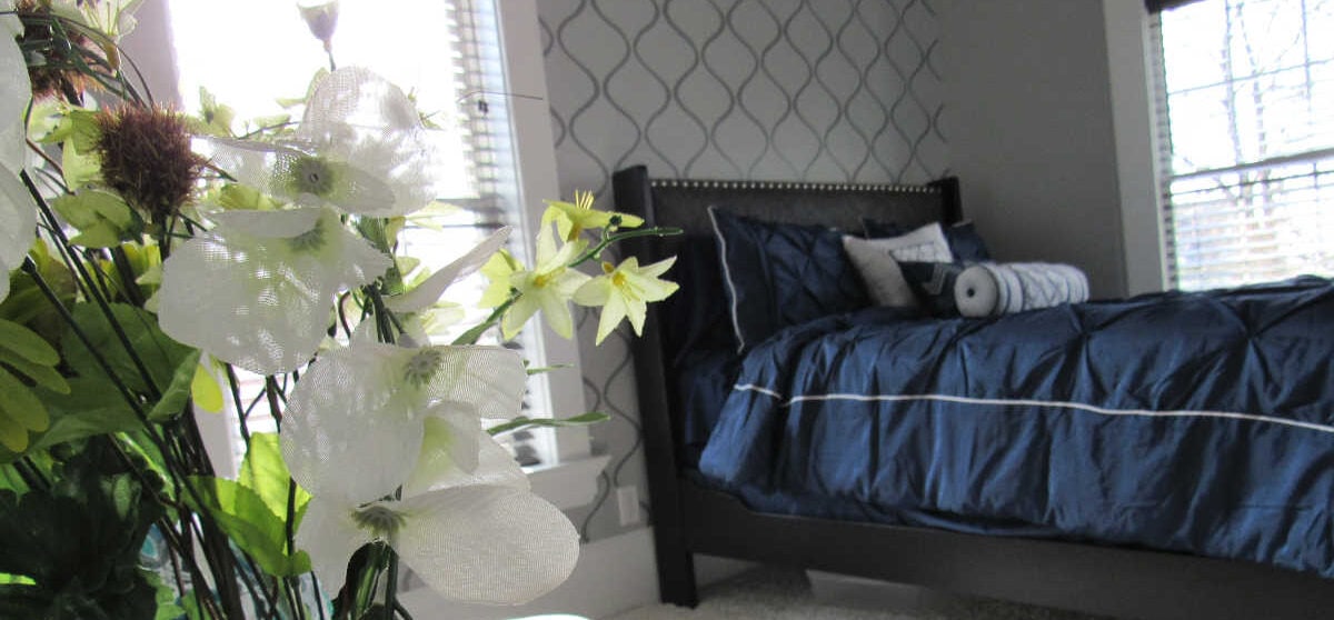 Master bedroom reveal with navy bed and gray stenciled wall