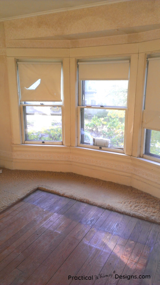 Wooden floor showing in a cut out of the carpeted master bedroom floor.