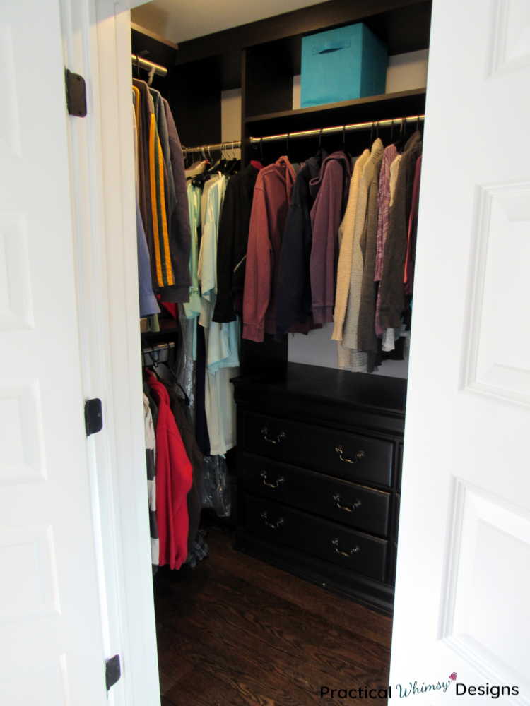 Master closet with clothes hanging in it