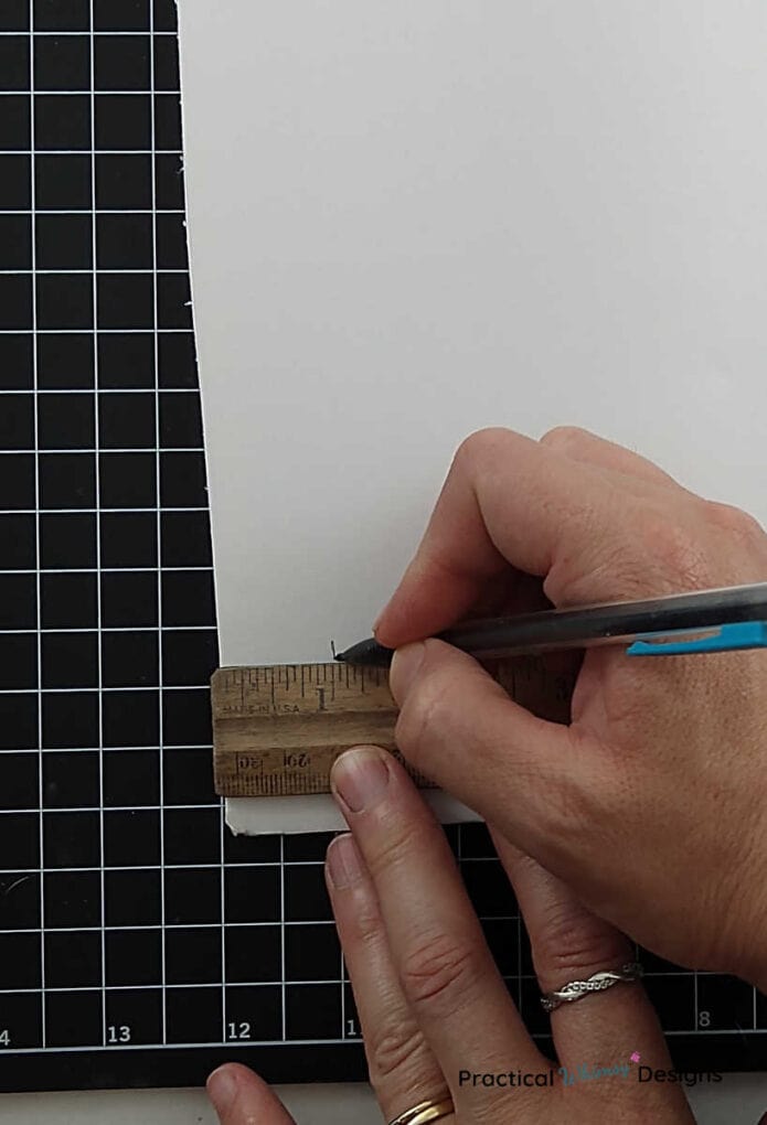 Marking one inch on poster board with a ruler and pencil.
