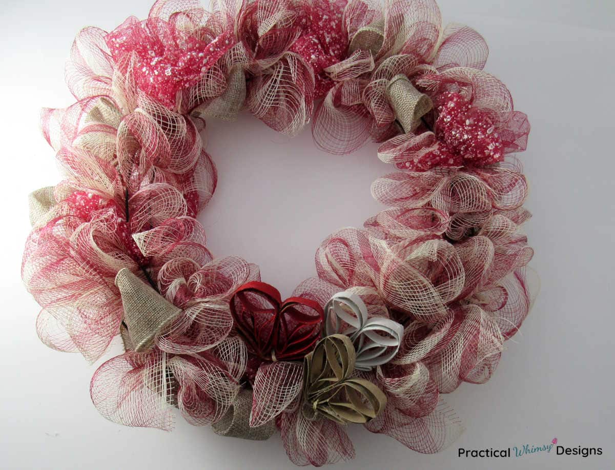 Red mesh and burlap wreath with toilet paper roll hearts.