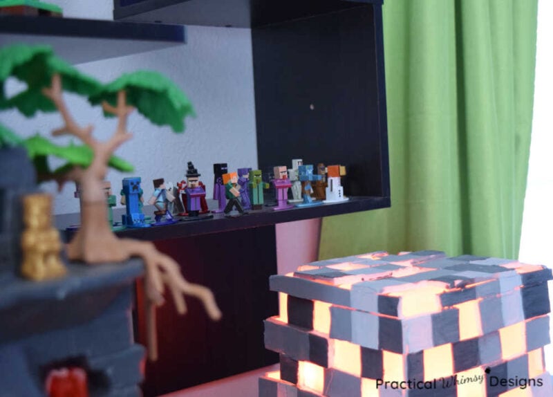 Minecraft figures on shelf behind pixelated light