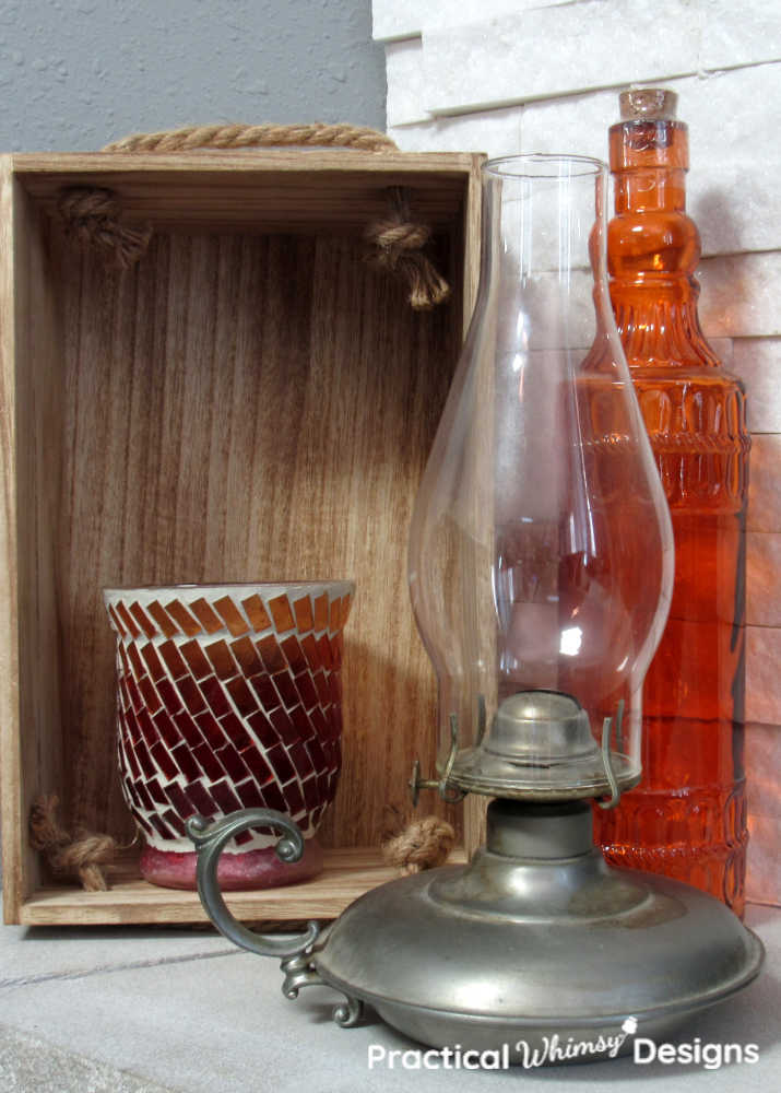 Orange vase, lantern, and candle in a box.