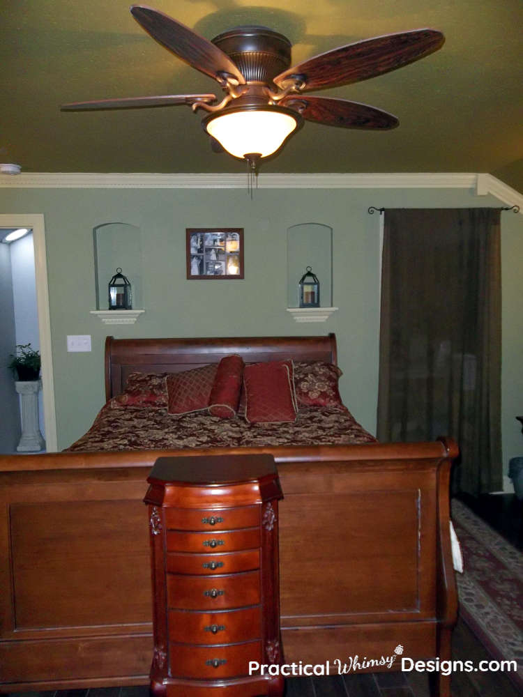 Queen sleigh bed in master bedroom with red and gold comforter