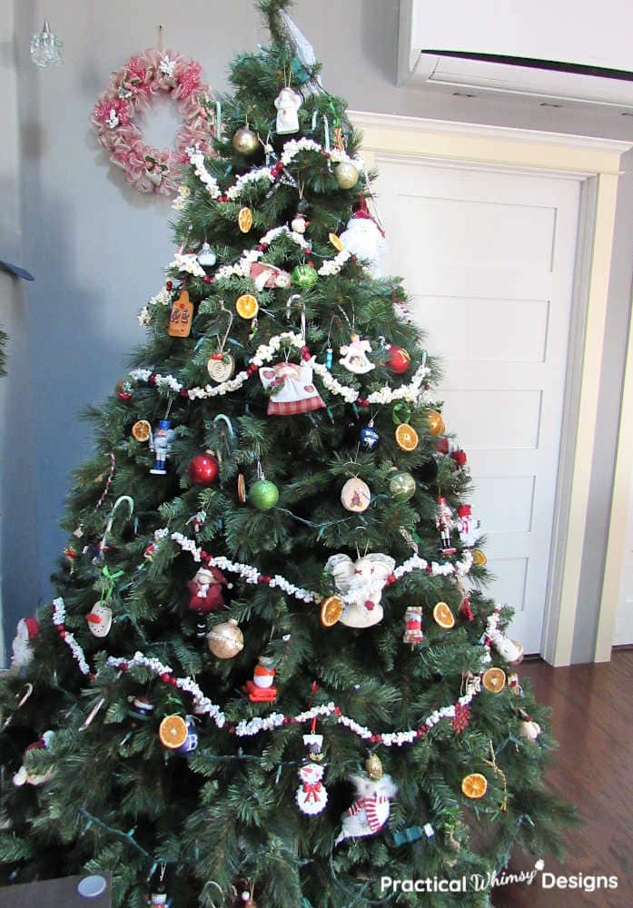 Mesh wreath hanging by old fashioned Christmas tree.