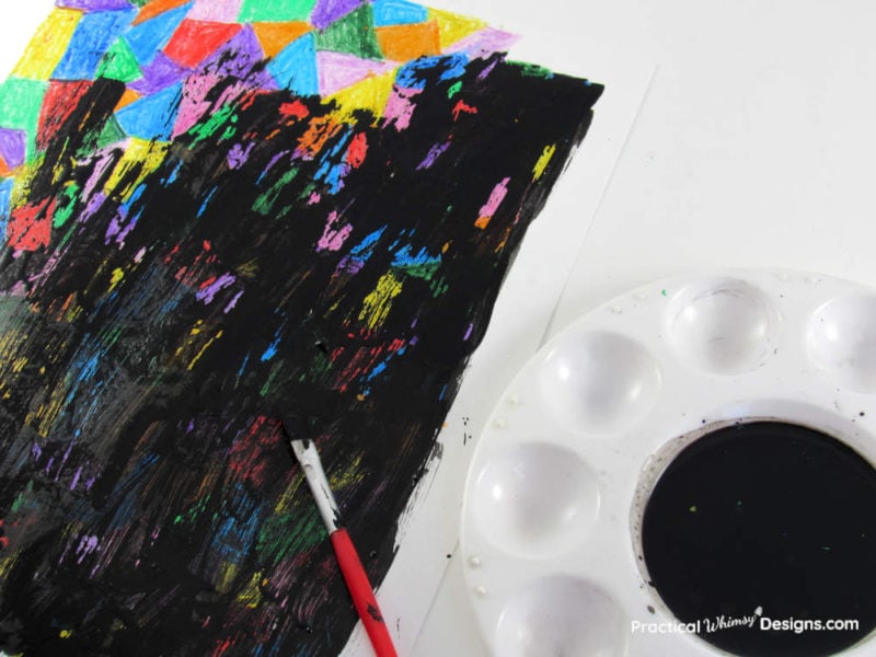 Painting acrylic black paint over crayon