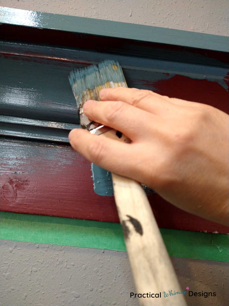 Painting wooden shelf on a wall with a paint brush 
