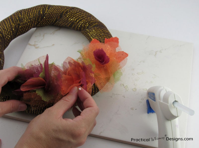 Pinning flowers onto simple DIY fall wreath