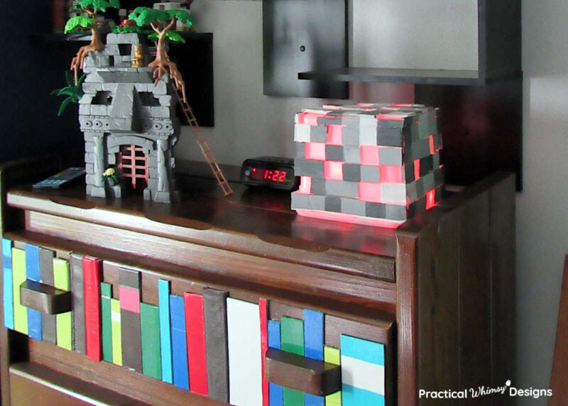 Pixelated brick video game light on dresser in bedroom.