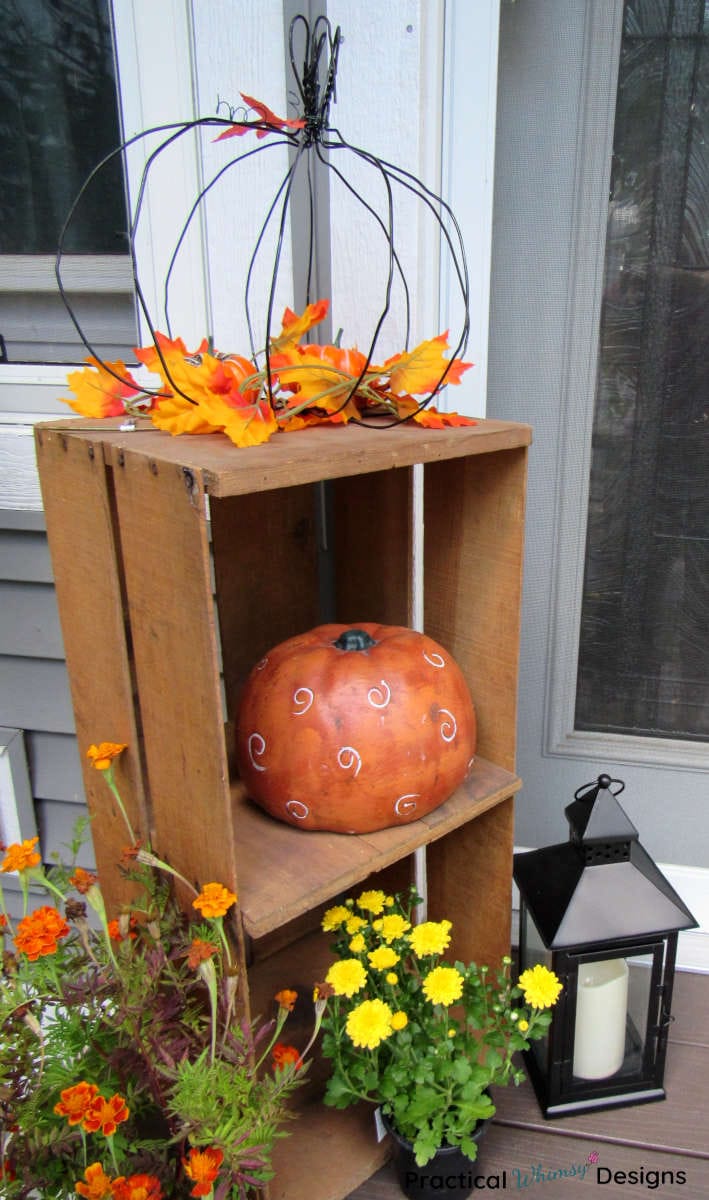 Fall pumpkins and flowers on crate