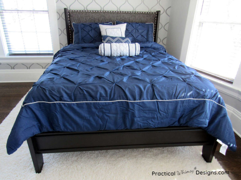 Bronze queen bed with blue comforter in master bedroom