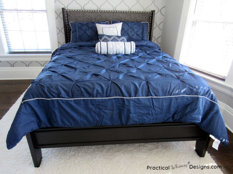 Modern queen sleigh bed makeover with blue comforter and throw pillows on it