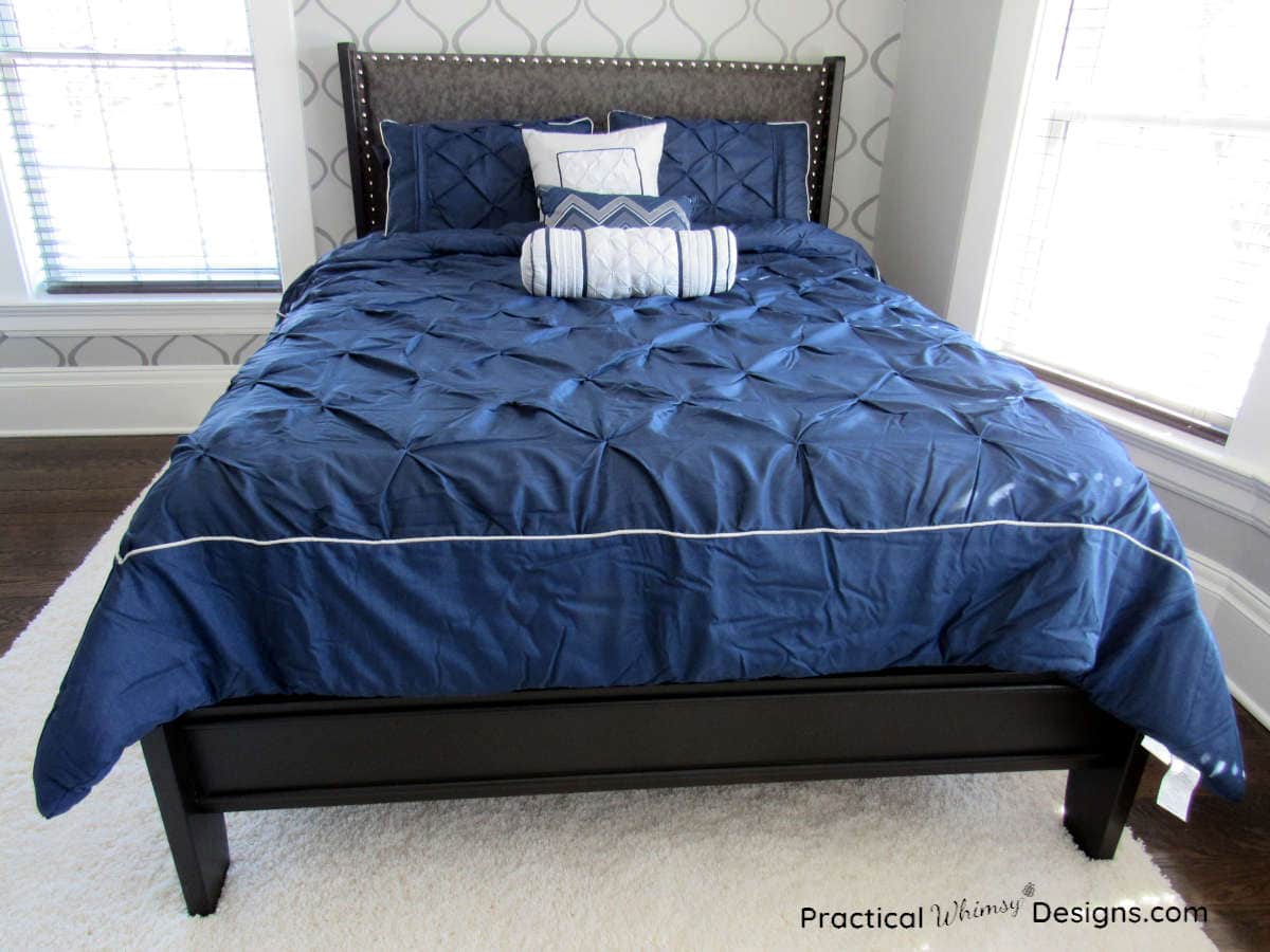 Bronze queen bed with blue comforter in master bedroom