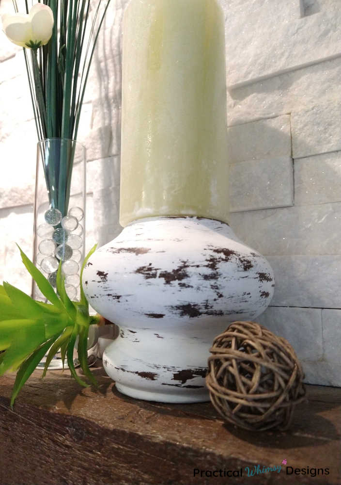 Farmhouse candlestick on mantel with onion grass flower in vase.