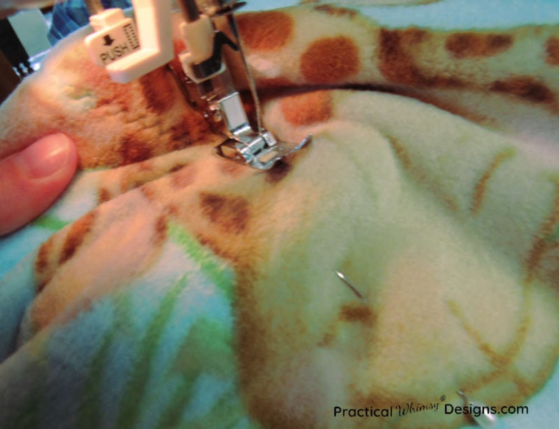 Sewing a zigzag stitch around edge of blanket
