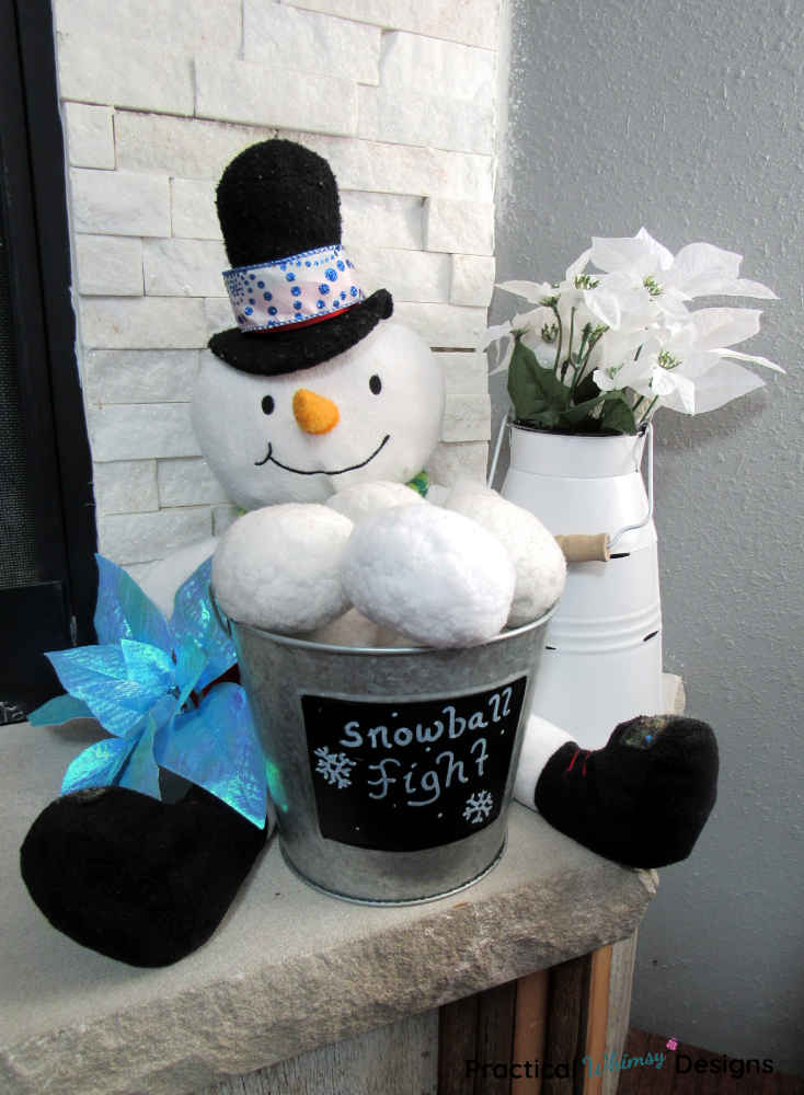 Snowman, snowballs and flowers on hearth.