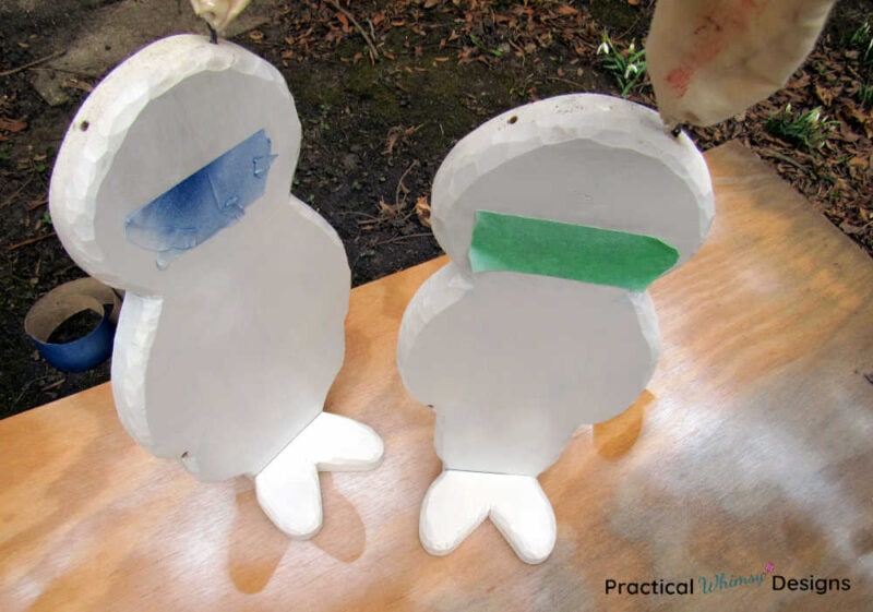 Painted wooden bunnies with painters tape on faces