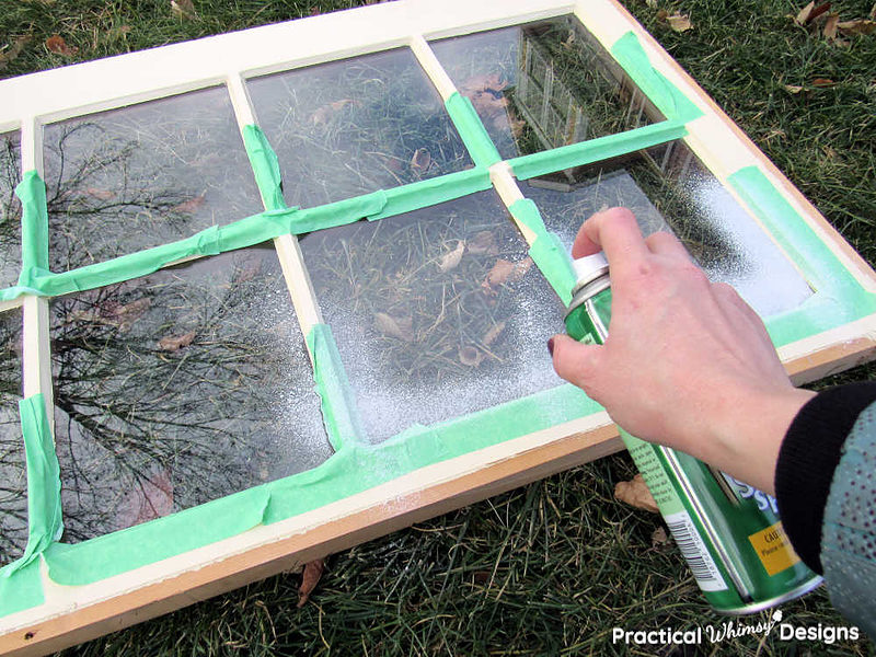 Spraying grided window with spray snow outside.