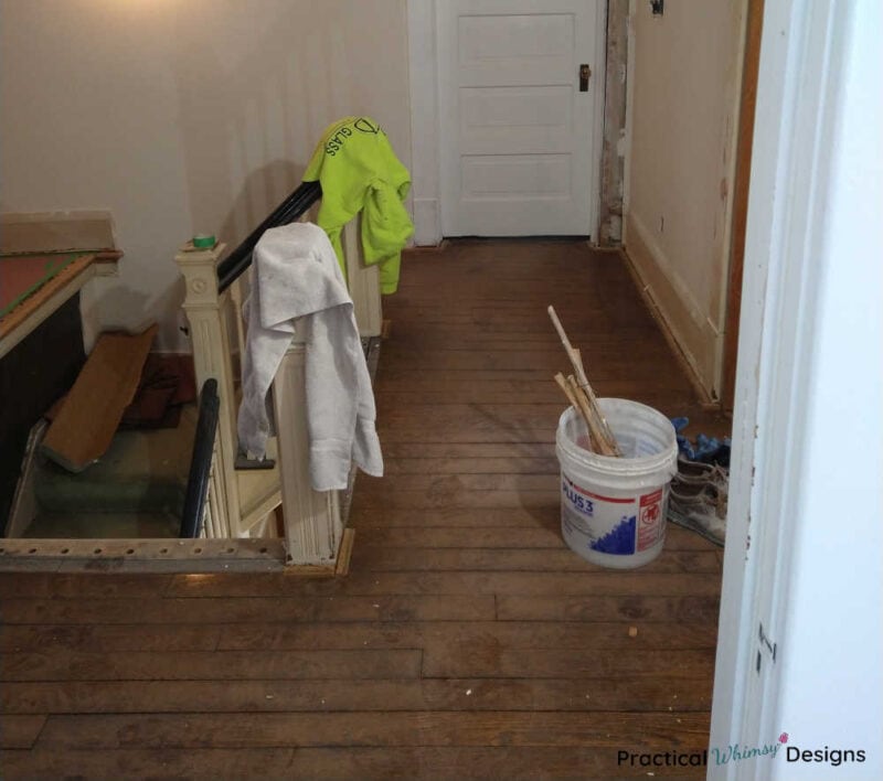 Stairs landing with unfinished hardwood floor