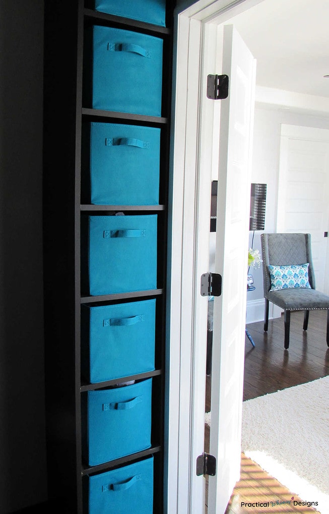 Teal fabric boxes as underwear storage in a closet storage cubby.
