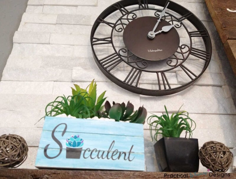 Succulent box planter with clock on mantel.