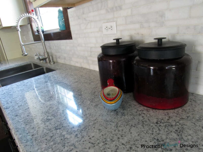 Red flour and sugar canisters on quartz counter in kitchen reveal