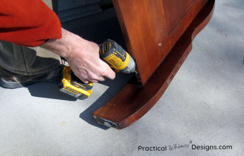 Taking apart the queen headboard screws with an electric drill.