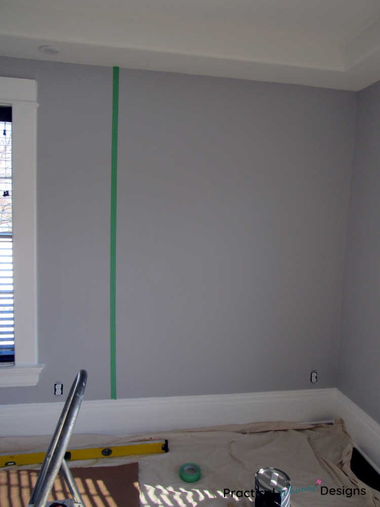 Vertical green painter's tape line on wall to help measure start of stencil.