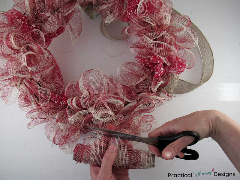 Trimming deco mesh ribbon with scissors.