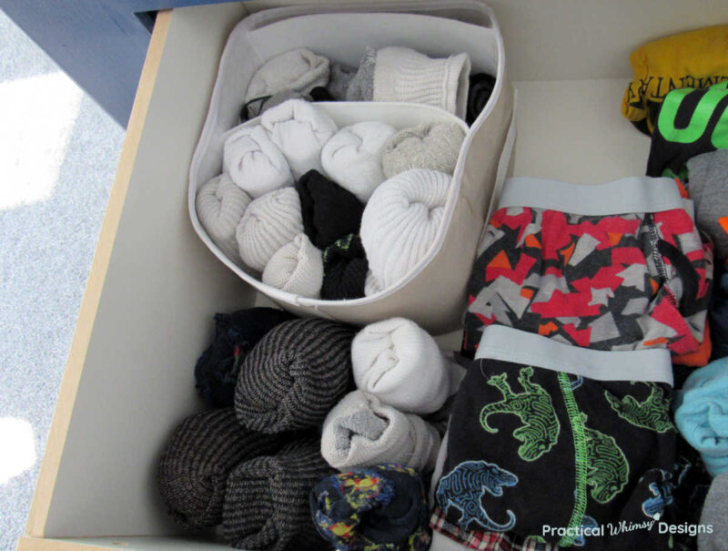 Underwear and socks organized and divided with a fabric box in a drawer.