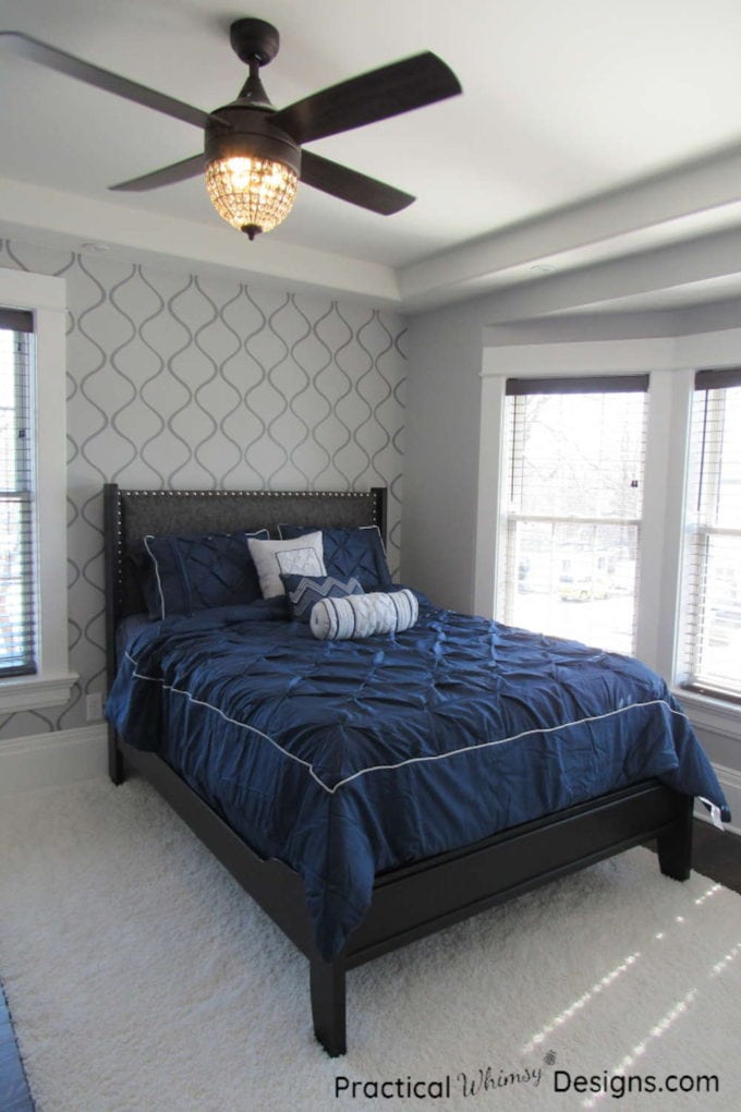 Navy blue bed next to grey stenciled wall in master bedroom