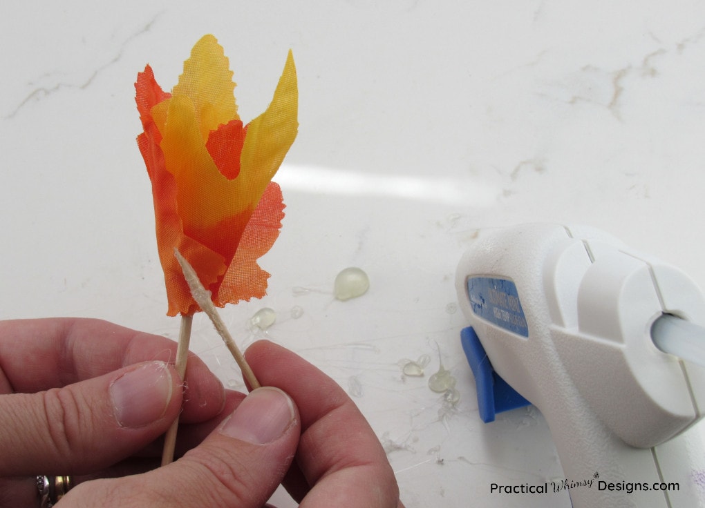 Spreading glue with a toothpick onto the fabric flower