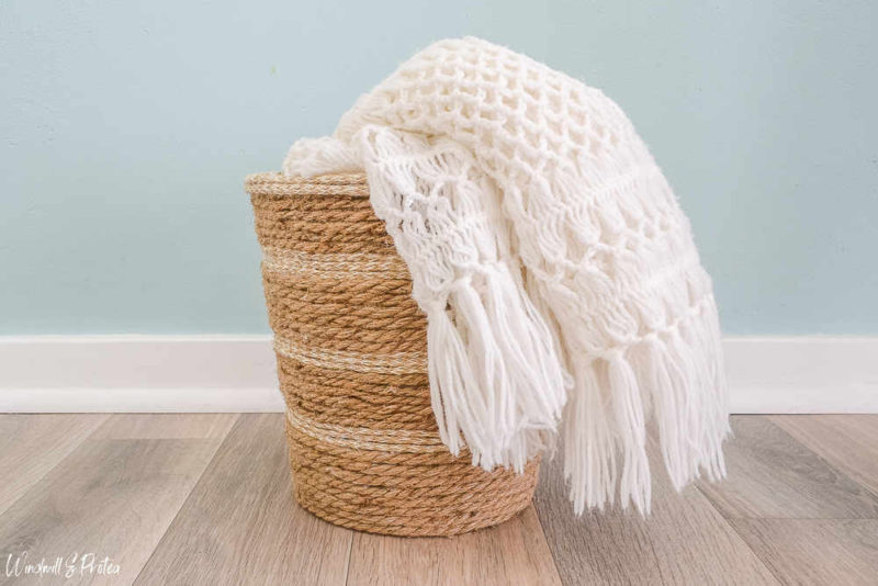 Rope basket with white blanket draped across