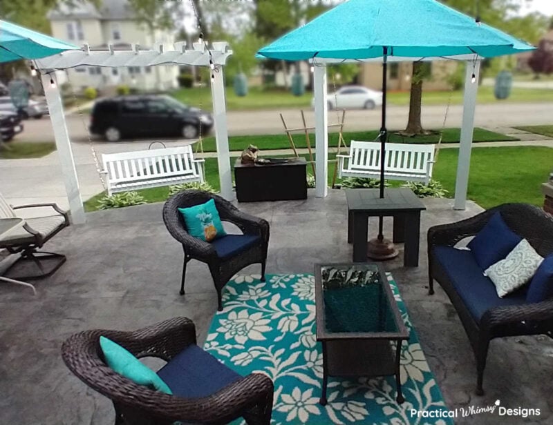 Patio with white diy wood pergolas and brown wicker furniture.