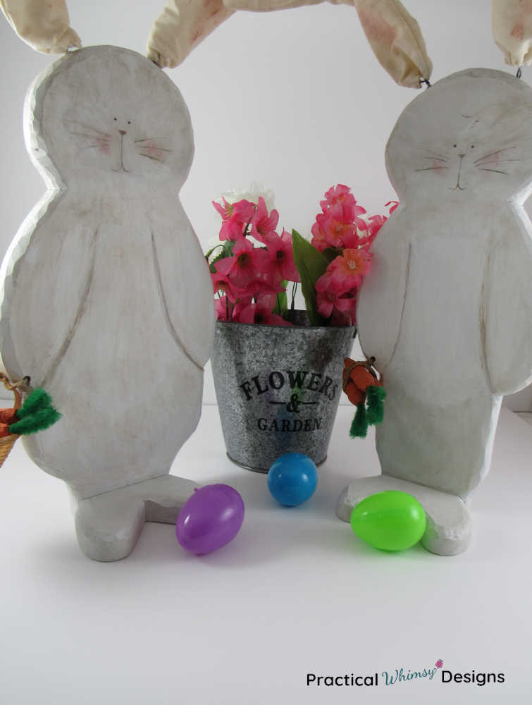 Wooden bunny decor by flowers and Easter eggs