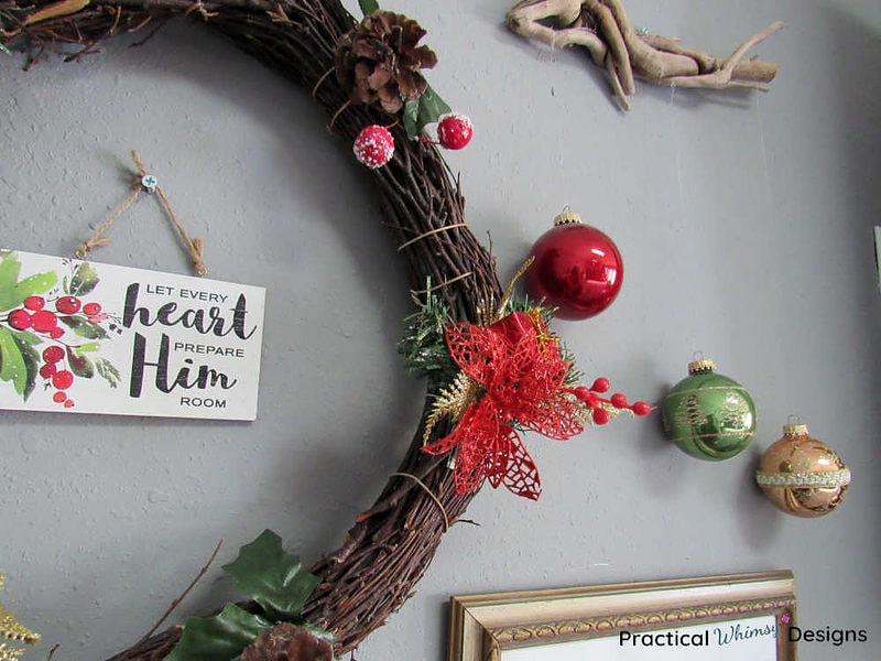 Christmas wreath, ornaments, and sayings hanging on wall.