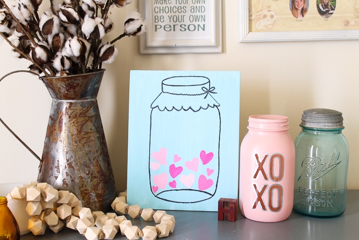 Mason jar canvas painting idea with pink hearts inside.