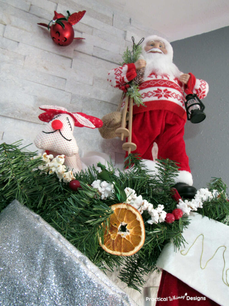 Santa and reindeer decor on mantel for old fashioned Christmas decorating idea.
